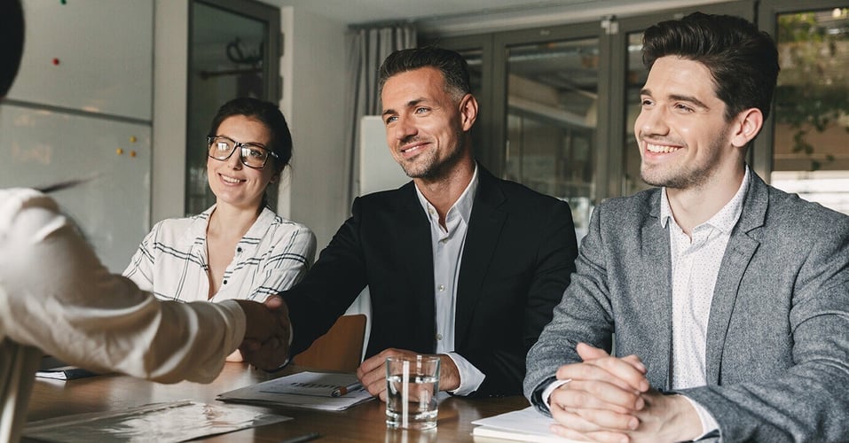Professionals shaking hands at a desk