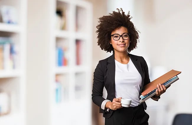 Business worker holding espresso cup and stack of papers looking forward
