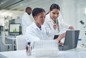 Two women technicians using a laptop in a laboratory.