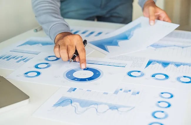 hand-pointing-to-data-on-a-paper-ss-1370206463-650x425