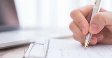 Hand writing on notebook with a pen.