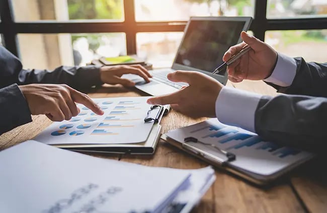 Hands gesturing over data and charts