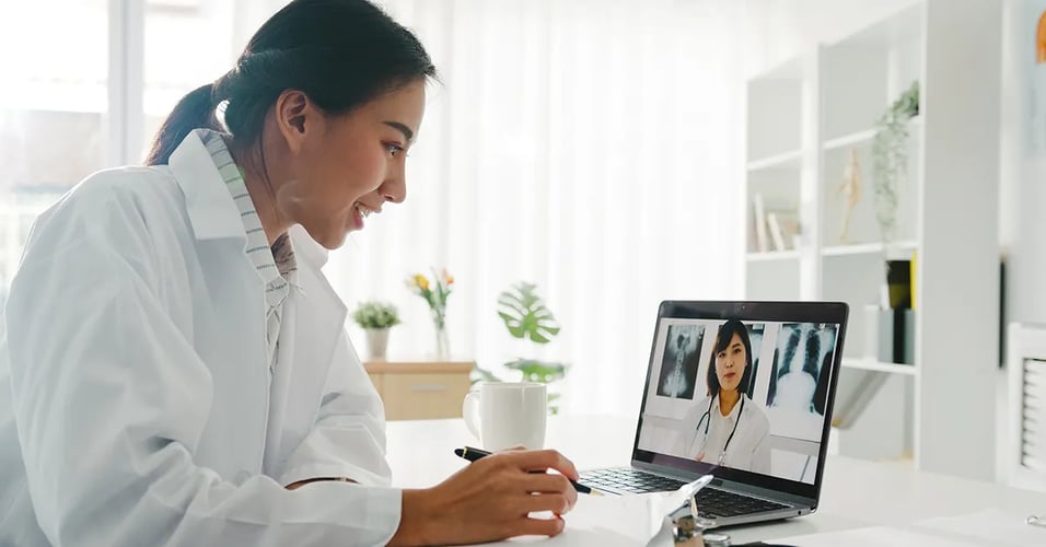Medical Professional interacting with another person virtually on a laptop