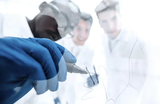 Health care provider writing on clear whiteboard