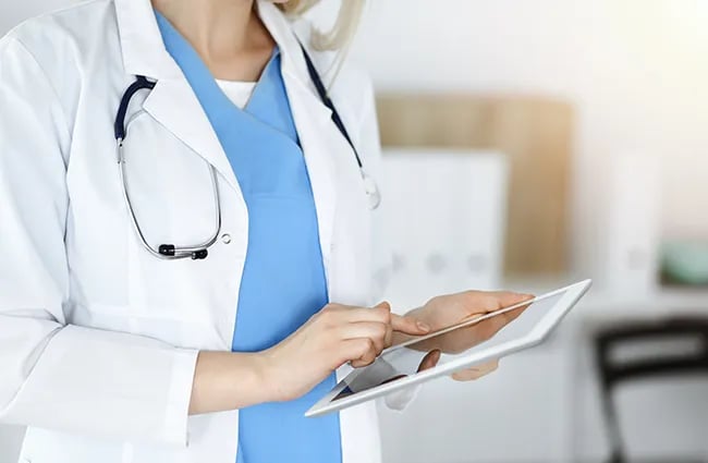 healthcare-provider-working-on-tablet-device-ss-1849836292-650x425