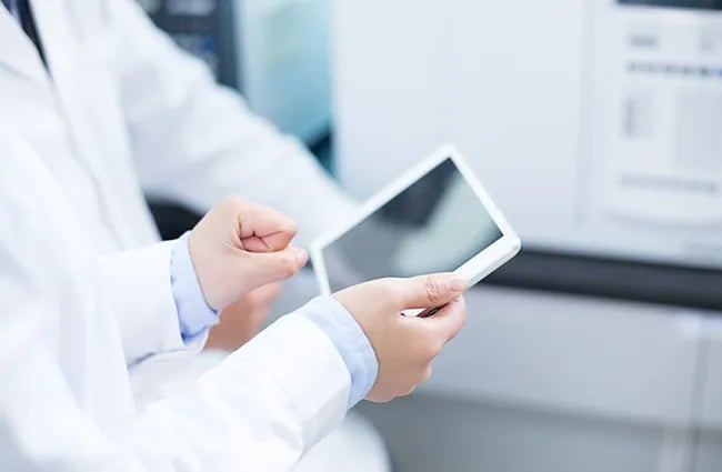 healthcare-workers-sharing-a-tablet-device-data-with-a-coworker-ss-385048636-650x425