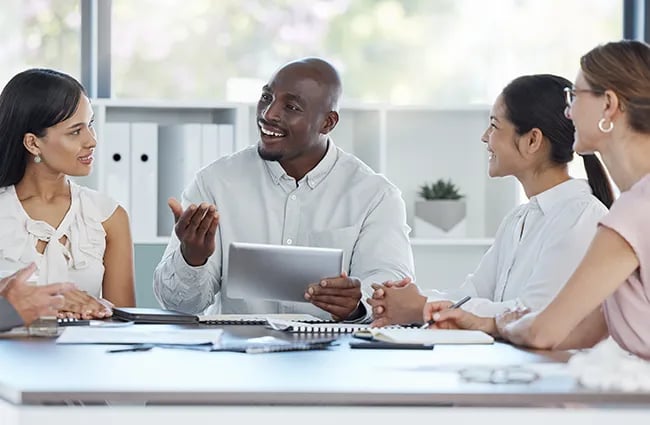 Several business professionals smiling at a business meeting