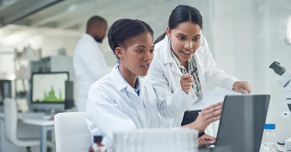 Lab techs working at a computer together