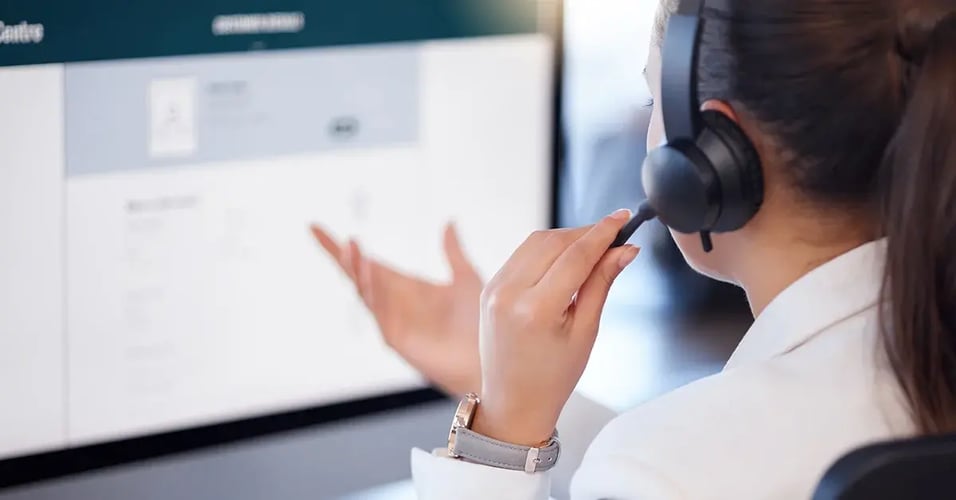 Contact center employee working at a desk and on the phone