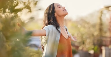 Woman extending arms enjoying sunset