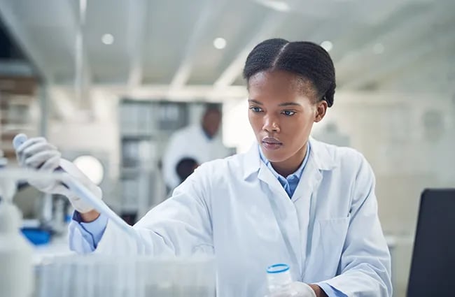 Woman in lab injecting test tubes