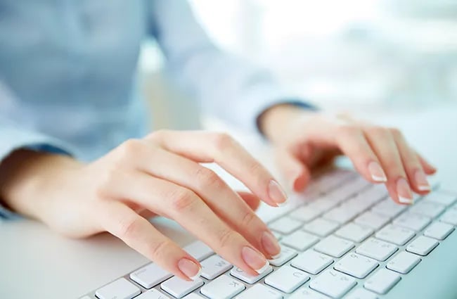 Woman typing on computer keyboard