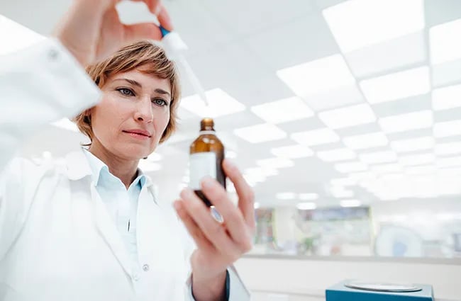 Woman using a dropper into a bottle